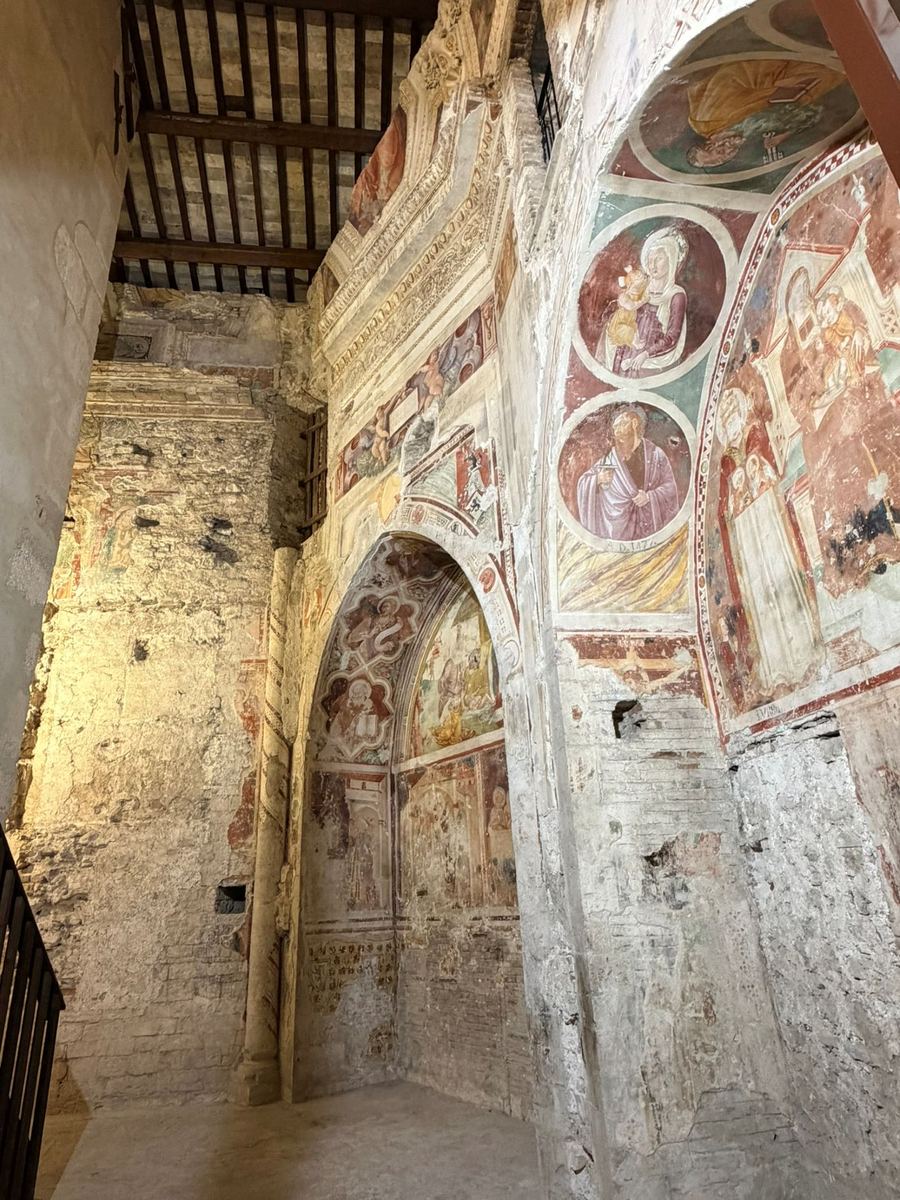 Layers of medieval frescoes on the walls of a church interior in Spoleto